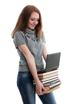 The attractive student stands with the laptop and books on a white background.