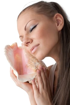 Beautiful woman listens seashell on a white background