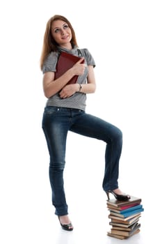 The attractive student stands with the laptop and books on a white background.