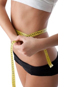 The beautiful girl measures a waist on a white background. Healthy lifestyles concept.