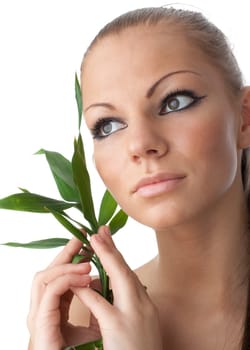 The attractive girl with a bamboo branch on a white background