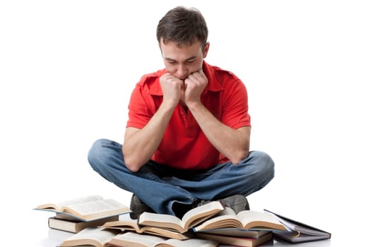 The clever young man sitting with books on a white background.