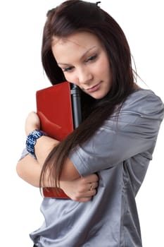 The attractive student stands with the laptop on a white background.
