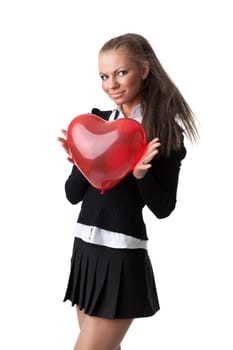 The beautiful girl holds in hands a red heart on a white background.