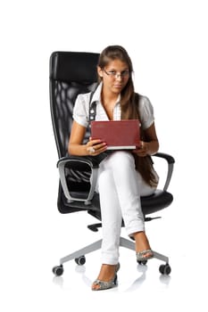 The attractive young woman with the laptop sits in an armchair on a white background.