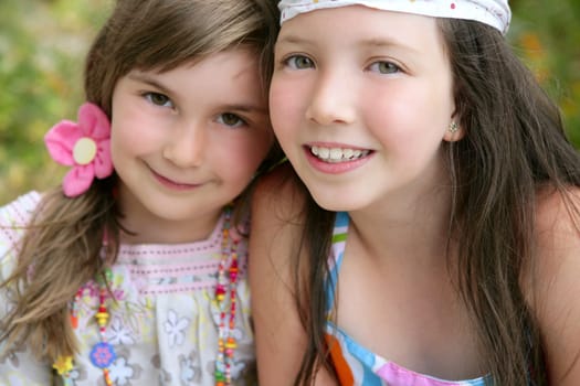 closeup portrait of two little happy beautiful girl sisters