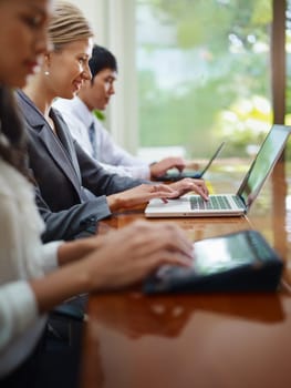 Group of businesspeople meeting in conference room and using laptop computers. Side view, copy space