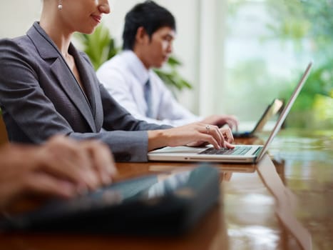 Group of businesspeople meeting in conference room and using laptop computers. Side view, copy space
