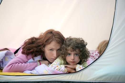 Camping tent vacation with mother and two little daughters
