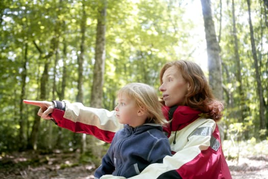Beautiful blond little daughter with her mother inn the forest