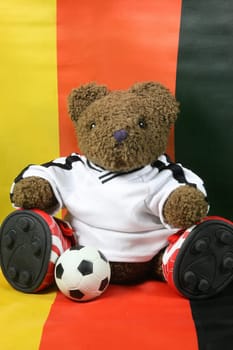 Football teddy bear in front of the German flag