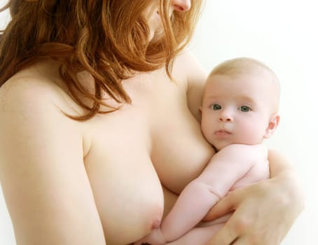 mother holding nude baby in arms on her breast