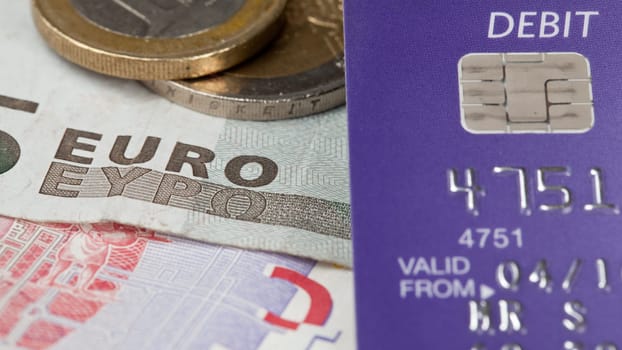 Macro of debit card and on top of euro note to illustrate currency crisis in Europe