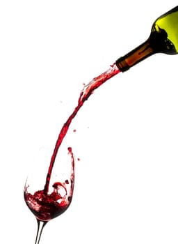 Red wine being poured directly from bottle into a large goblet