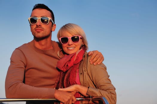 happy young couple in love  have romantic time at summer sunset   at ship boat while  representing urban and countryside fashin lifestyle