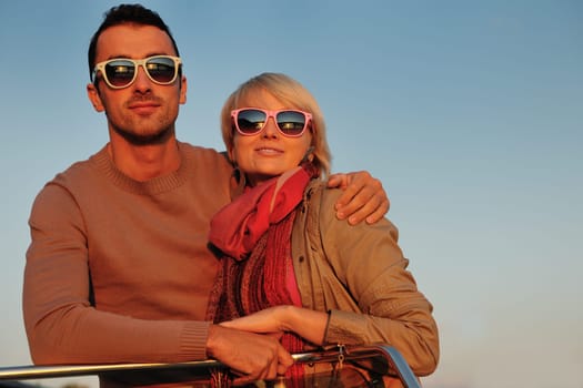 happy young couple in love  have romantic time at summer sunset   at ship boat while  representing urban and countryside fashin lifestyle