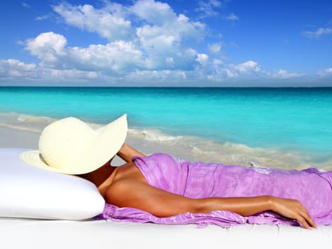 Caribbean tourist resting in tropical beach with hat lying on resort bed
