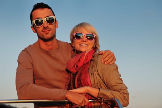 happy young couple in love  have romantic time at summer sunset   at ship boat while  representing urban and countryside fashin lifestyle