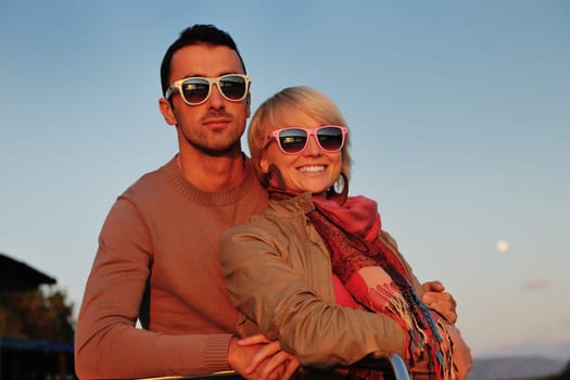 happy young couple in love  have romantic time at summer sunset   at ship boat while  representing urban and countryside fashin lifestyle