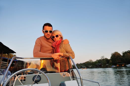 happy young couple in love  have romantic time at summer sunset   at ship boat while  representing urban and countryside fashin lifestyle