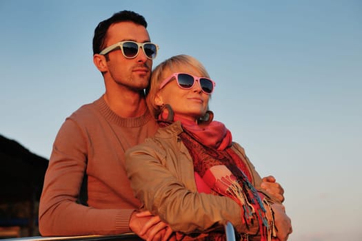 happy young couple in love  have romantic time at summer sunset   at ship boat while  representing urban and countryside fashin lifestyle