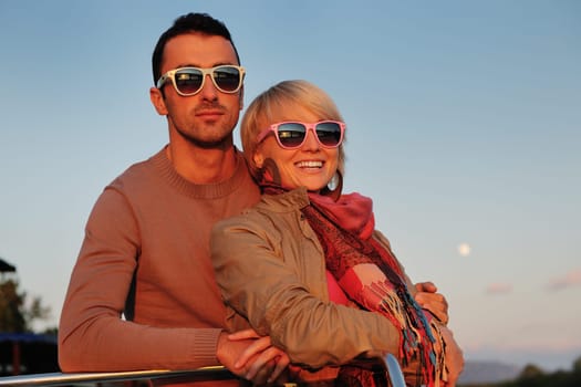 happy young couple in love  have romantic time at summer sunset   at ship boat while  representing urban and countryside fashin lifestyle