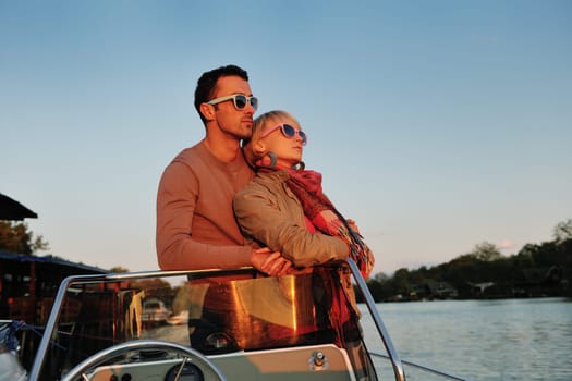 happy young couple in love  have romantic time at summer sunset   at ship boat while  representing urban and countryside fashin lifestyle