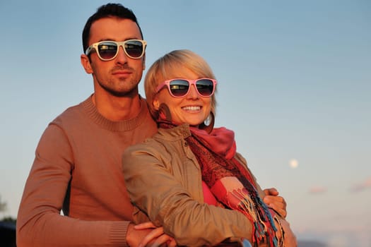happy young couple in love  have romantic time at summer sunset   at ship boat while  representing urban and countryside fashin lifestyle
