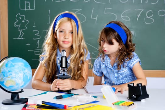 children girls at school classroom with world map and microscope