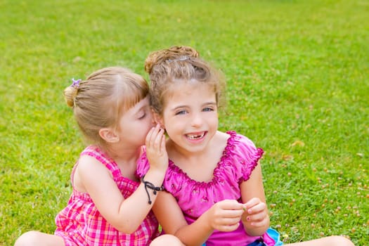 children girl sister friends whispering ear in green grass park