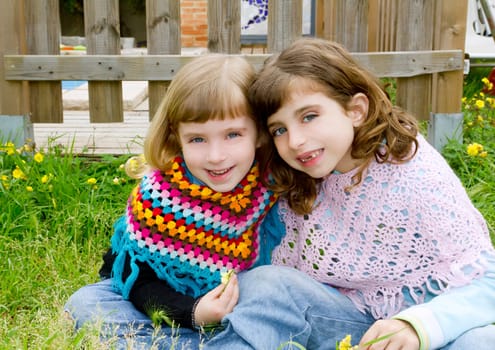 children sister girls smiling in meadow spring fence yellow flowers