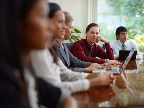 young business man working as manager and smiling at camera during meeting with colleagues