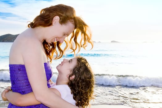 Daughter and mother hug on the beach of Ibiza Cala conta