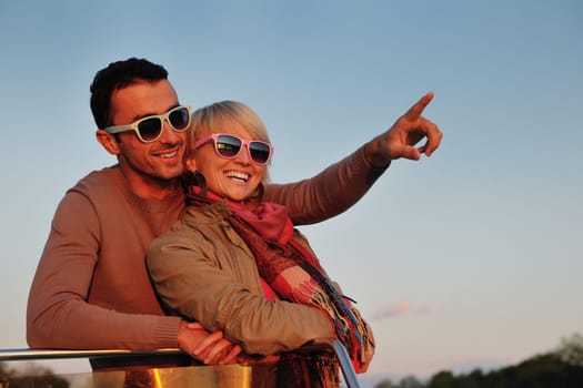 happy young couple in love  have romantic time at summer sunset   at ship boat while  representing urban and countryside fashin lifestyle