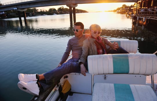 happy young couple in love  have romantic time at summer sunset   at ship boat while  representing urban and countryside fashin lifestyle