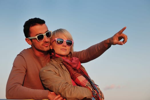 happy young couple in love  have romantic time at summer sunset   at ship boat while  representing urban and countryside fashin lifestyle