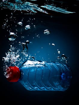 Bottled water on a black/blue background with air bubbles