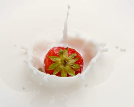 Delicious strawberry splashing into milk