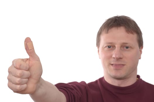 A man holds his thumb up with plaster
