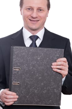 A man in a tie and suit holds a folder in his hands