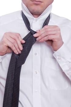 A man ties a tie