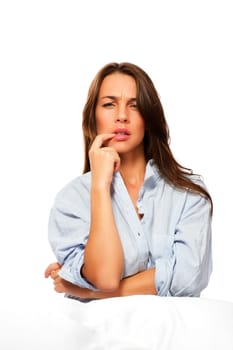Beautiful woman in pajamas thinking against white background