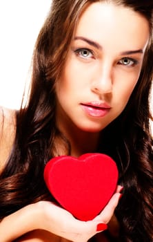 Beautiful woman holding small red heart against white background