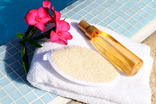 massage oil, shellfish and white towel beside a pool