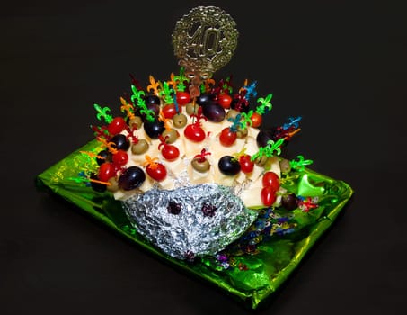 hedgehog made from sticks with delicious food - cheese, olives, tomatoes, grapes