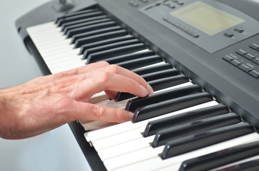 Single hand on electronic synthesizer playing music