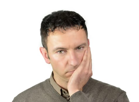 Good looking youg man with hand on his face because of tooth ache