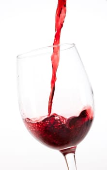 Red wine pouring into glass, isolated on white background