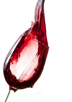 Red wine pouring into glass, isolated on white background