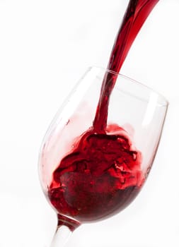 Red wine pouring into glass, isolated on white background